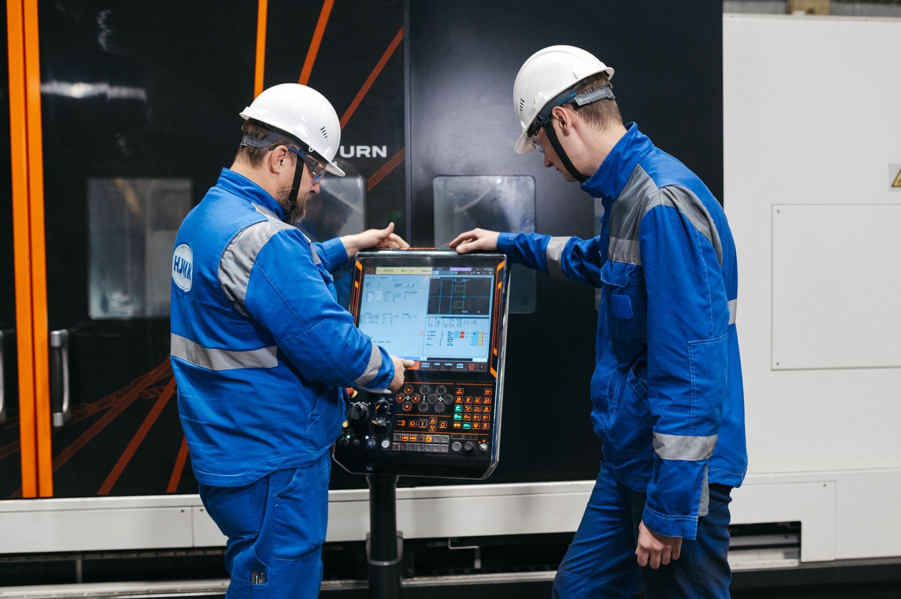 Two engineers collaborating beside industrial equipment